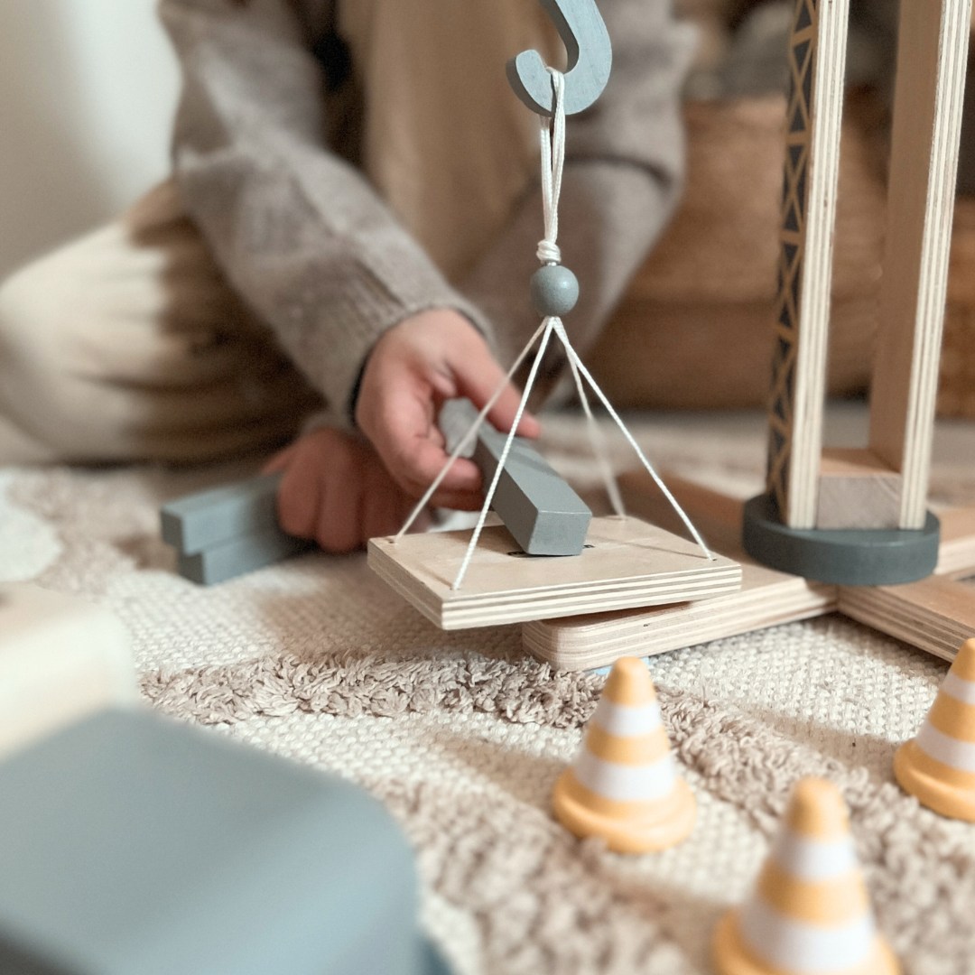 Holzbaustelle mit großem Mobilkran und Fahrzeugen, Turmkran